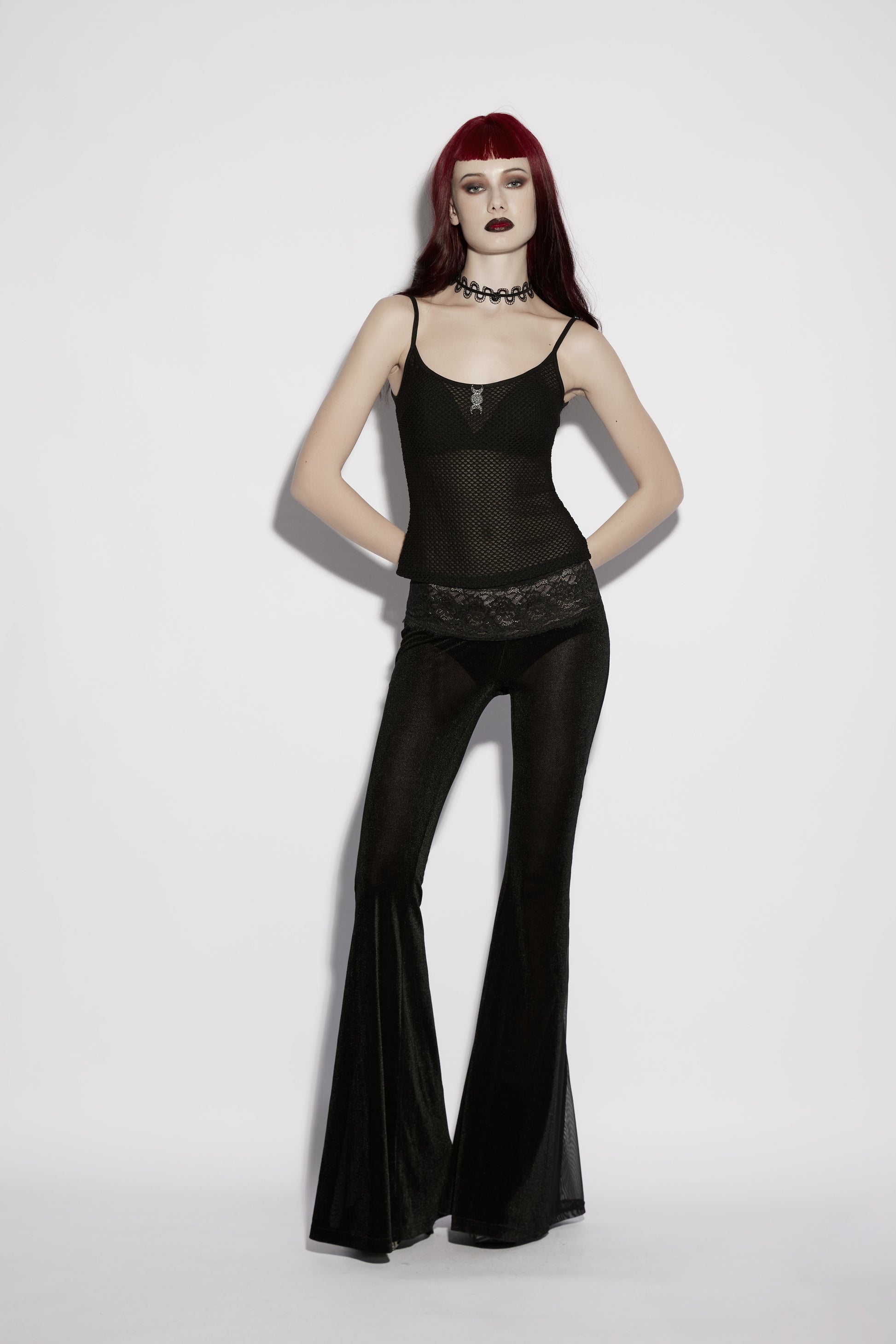 Model wearing Punk Rave Lilith Low Waist Flared Pants paired with sheer top, showcasing goth fashion style.