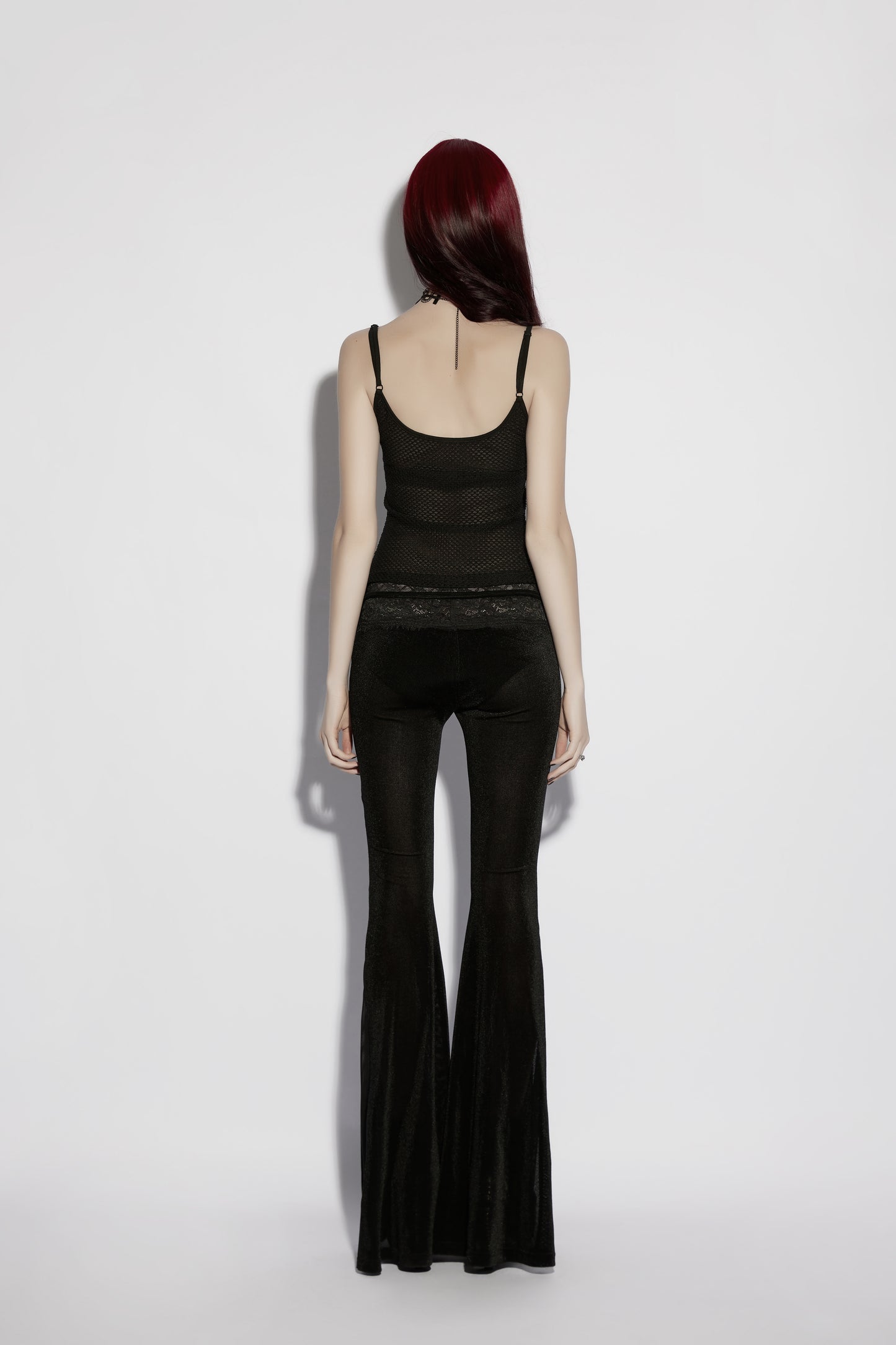 Back view of a model wearing Punk Rave Lilith Low Waist Flared Pants, showcasing sleek gothic styling.