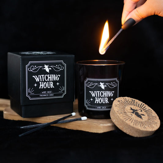 Gothic Gifts Witching Hour White Sage Candle shown with it's lid and box and a lit match