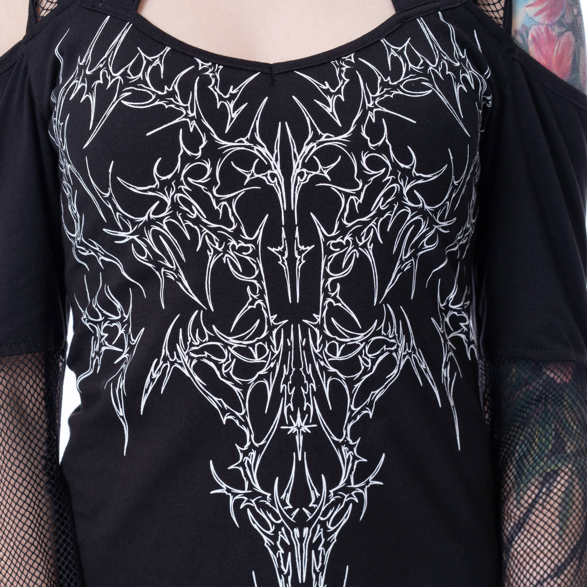 Black shirt with white intricate design worn by a person with tattoos.
