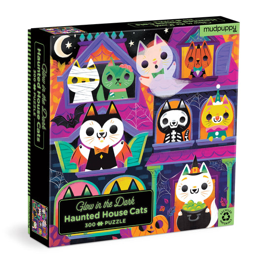 Front of the Haunted House Cats puzzle box, with cats in Halloween costumes peeking out of a purple and orange haunted house.