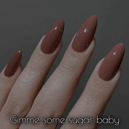 Warm nude nail polish showcased on stylish long nails, highlighting the rich caramel undertones of Gimme Some Sugar, Baby.