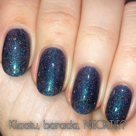 Dark holographic nail polish applied on fingernails, showcasing cosmic colors and shimmer from Klaatu Barada Necktie.