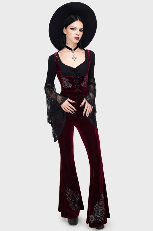 Woman wearing a black and red outfit with floral embroidery on a white background