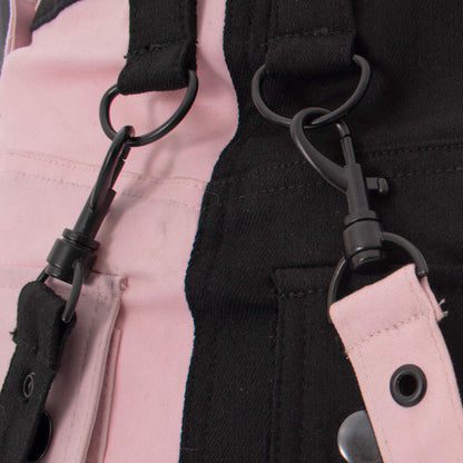 Close-up of gothic mini skirt black and pink strap detail showing industrial-inspired hardware.