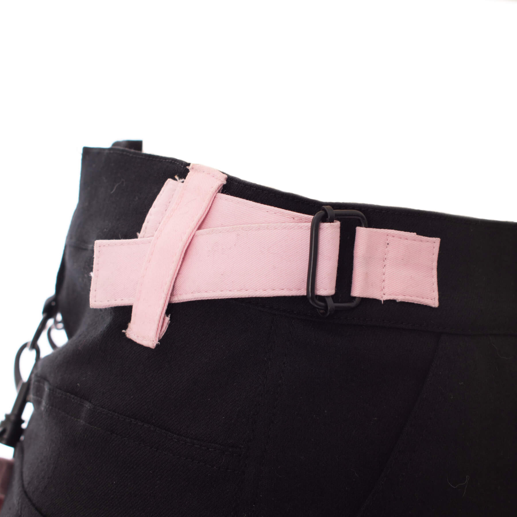 Gothic mini skirt black and pink strap detail showcasing adjustable buckle design for edgy alternative styling.
